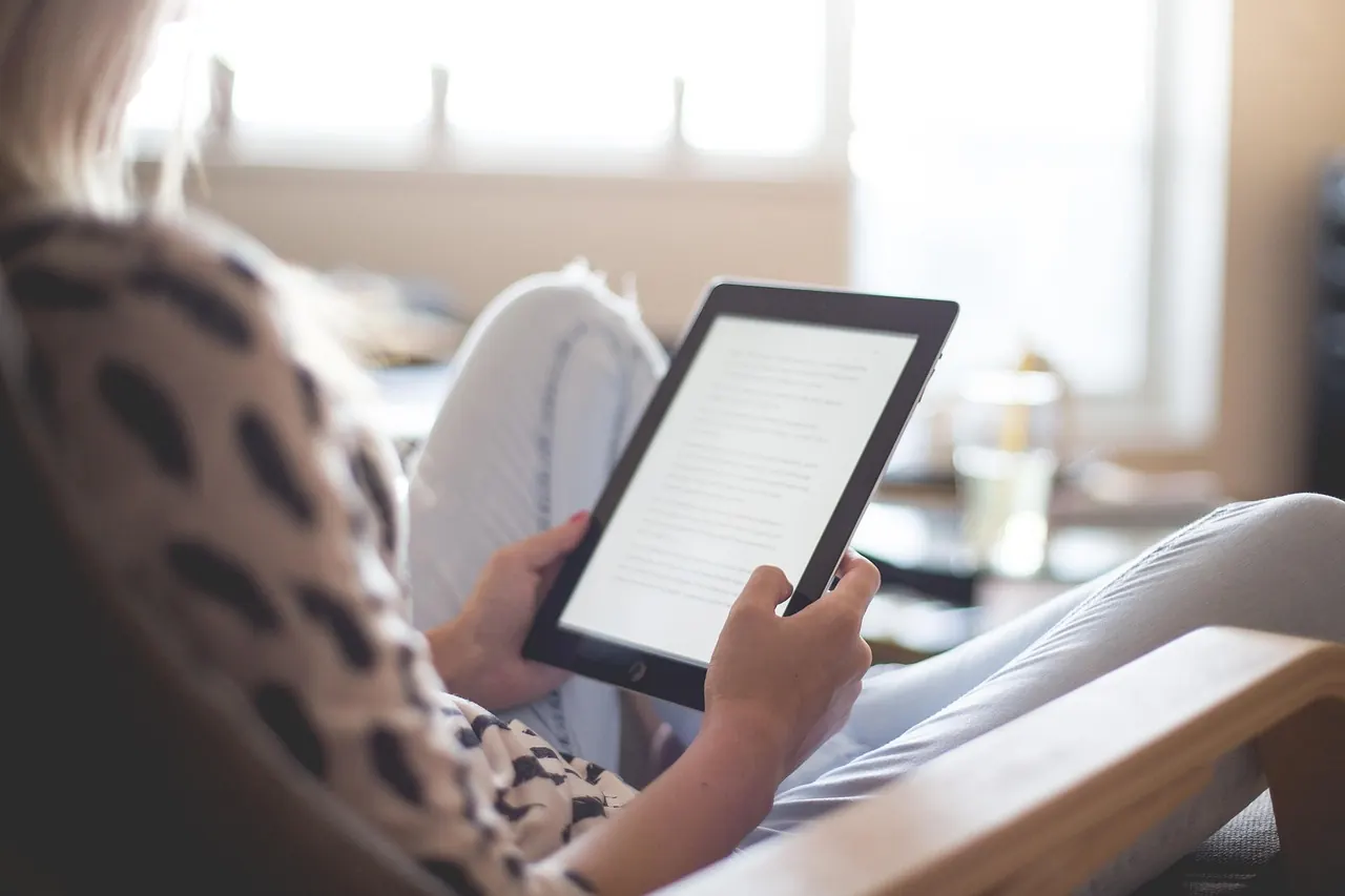 Lectrice qui consulte un guide sur une liseuse, au calme