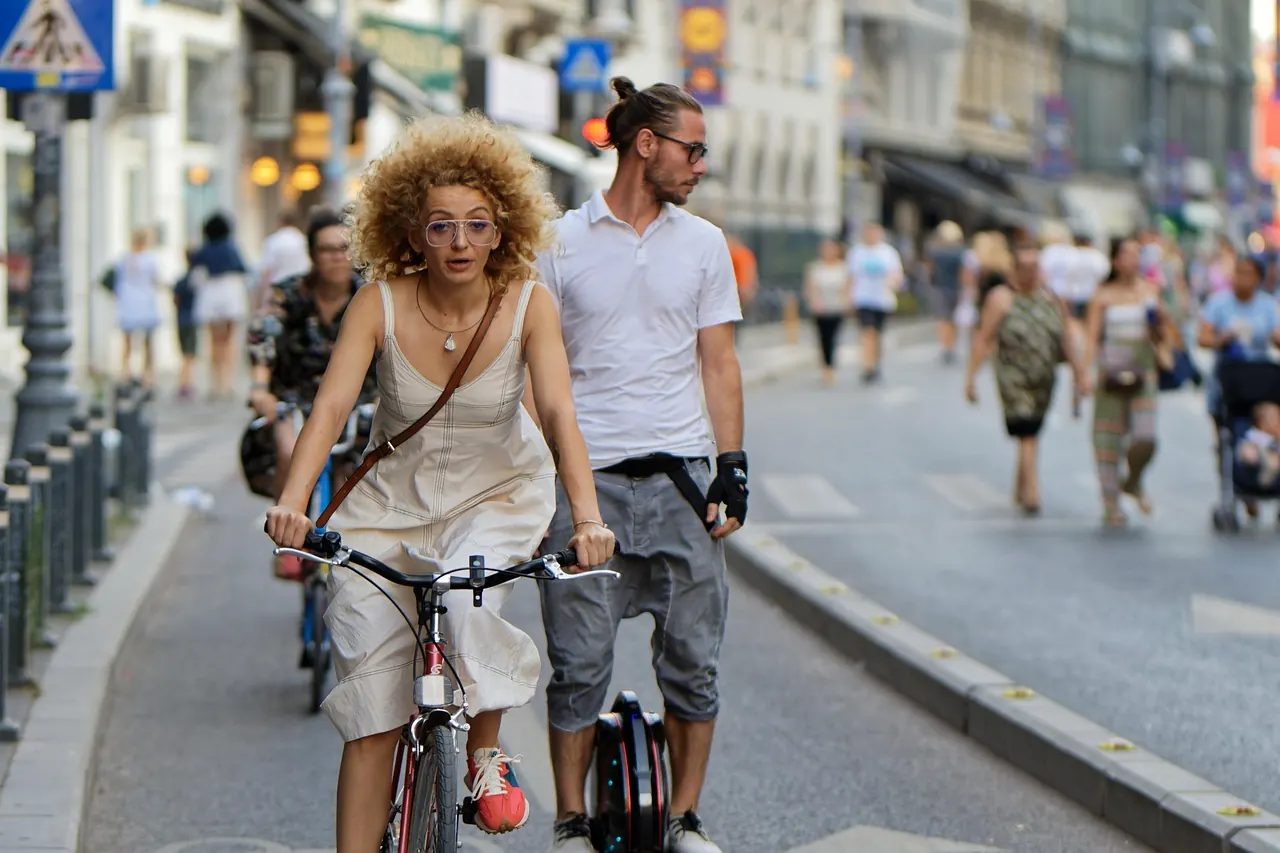 Deux personnes à vélo dans une rue animée
